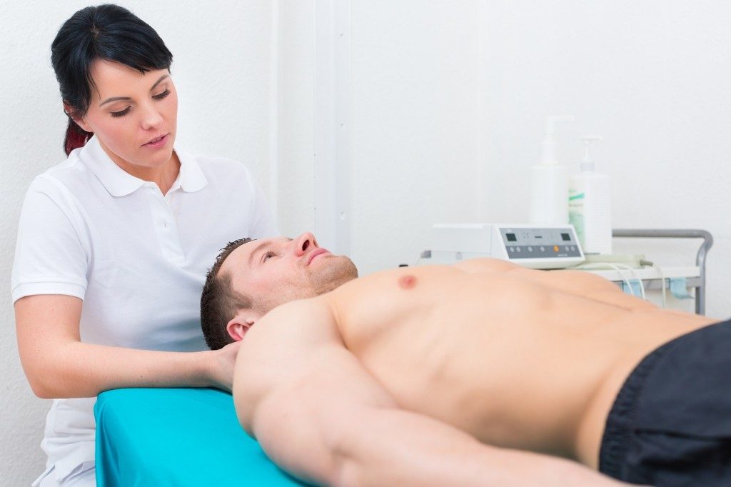 Patient at the physiotherapy getting medical massage from therapist