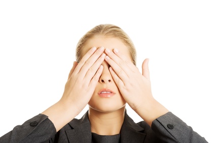 Blonde woman covering her face with both hands